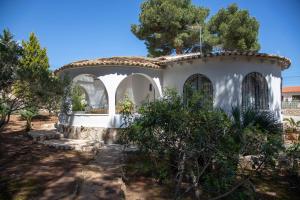 a white house with a tree in front of it at Quinta la Sal by SingularStays in Jávea