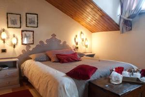 a bedroom with a large bed with red pillows at Hotel PIAN DEL SOLE Claviere in Claviere