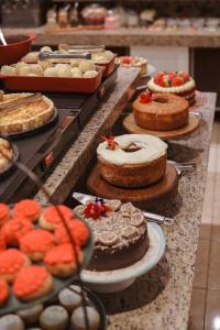 a buffet line with cakes and pies and other desserts at Hotel Glamour da Serra in Gramado