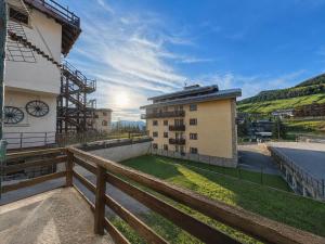 a building with a wooden fence next to a building at Hostdomus - Fraiteve Suite in Sestriere +3 photos