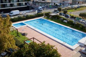 an overhead view of a large swimming pool at Beachfront Apartment with Sea Views & Pool - El Puig in El Puig
