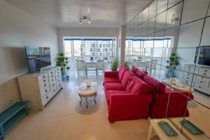 a living room with a red couch and a table at Beachfront Apartment with Sea Views & Pool - El Puig in El Puig