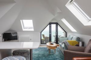 a loft conversion with a living room with a couch and chairs at Seaview apartment in Southbourne