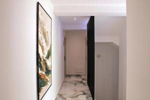 a hallway with a mirror and a painting on the wall at Villa Blanc in Shëngjin