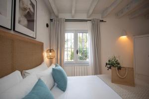 a bedroom with a white bed with a window at Quinta la Sal by SingularStays in Jávea +81 photos