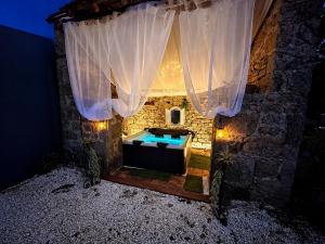 a bath room with a tub in a stone building at Domaine VALENQUERCY in Cazillac