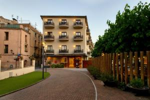 a building with balconies and a brick street at Balneari Termes Victòria in Caldes de Montbui