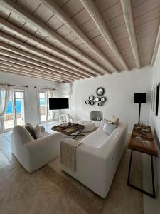 a living room with a white couch and a table at Topos exclusive Mykonos in Agios Ioannis Mykonos