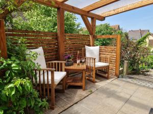 a wooden pergola with a table and chairs on a patio at Charme im Fachwerkhaus in Sugenheim