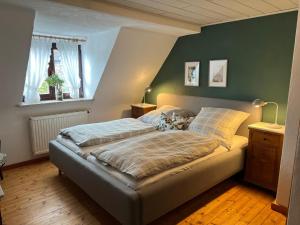 a bedroom with a bed and a green wall at Charme im Fachwerkhaus in Sugenheim