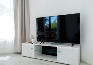 a white entertainment center with a flat screen tv on it at Summer Apartments Kabakum by Flat Manаger in Golden Sands