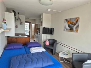 a bedroom with a blue bed and a living room at Marx Motel in Valkenburg +66 photos
