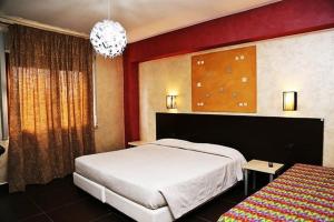 a bedroom with a white bed and a red wall at Albergo Miramonti in Gangi