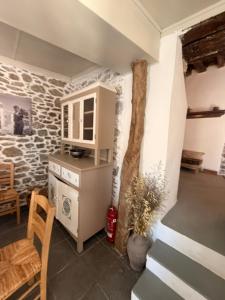a kitchen with a cabinet and a table and chairs at Grandma Stella's Old House in Apolakkiá