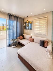 a living room with a couch and a window at ORLANDO LUXURY APARTAMENT in Adeje +47 photos