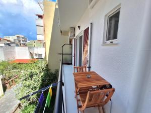 a balcony with a wooden chair and a table at The Handcrafted Haven 2 min to Central Square in Missolonghi