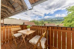 a wooden deck with a table and chairs on it at 3 Rivers Apartment in Radovljica