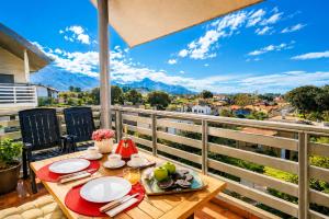 a table on a balcony with a view of the mountains at El Arcin - Piscina, terraza y parking en Llanes in Llanes