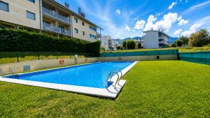 a swimming pool in the middle of a grassy yard at El Arcin - Piscina, terraza y parking en Llanes in Llanes