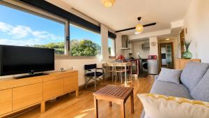 a living room with a large flat screen tv at El Arcin - Piscina, terraza y parking en Llanes in Llanes