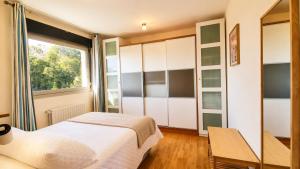 a bedroom with two beds and a window at El Arcin - Piscina, terraza y parking en Llanes in Llanes +27 photos