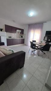 a living room with a couch and a table with chairs at Apartmani Azik in Lopar