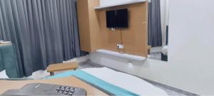a hospital room with a bed and a tv at Hotel Radhe Inn in Gandhinagar