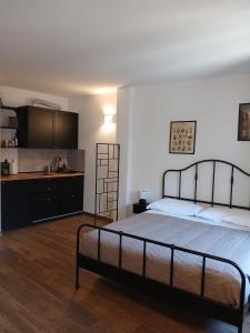 a bedroom with a large bed and a kitchen at La Casa nel Borgo in Muggia
