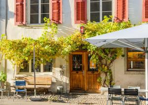a table and chairs and an umbrella in front of a building at Hotel Genossenschaft Kreuz in Solothurn