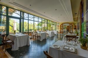a restaurant with white tables and chairs and windows at Hotel MR Les Rotes in Denia