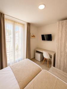 a bedroom with a bed and a desk and a television at Hostal Rural La Mejorada in Alpera +34 photos