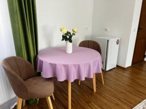 a purple table with a vase of flowers on it at Готель Сузірʼя in Kolomiya