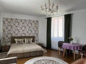 a bedroom with a bed and a chandelier at Готель Сузірʼя in Kolomiya