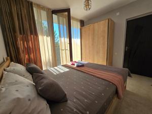 a bedroom with a bed and a large window at Dava&Davi in Ureki