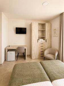 a bedroom with a bed and a desk with a computer at Hostal Rural La Mejorada in Alpera