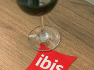 a glass of wine sitting on a table with a red napkin at ibis Mendoza in Mendoza