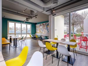 a cafeteria with tables and chairs and windows at ibis Köln Frechen in Cologne