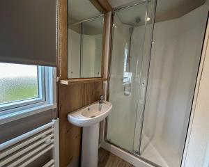 a bathroom with a sink and a glass shower at Ingoldale Holiday Park in Ingoldmells +26 photos