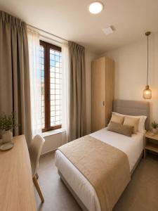 a bedroom with a bed and a desk and windows at Hostal Rural La Mejorada in Alpera