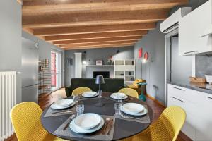 a kitchen and dining room with a table and yellow chairs at Lulli mansarda- 7Sundays in Milan