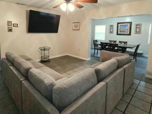 a large couch in a living room with a flat screen tv at White Door House! in Winter Haven