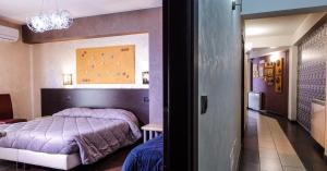 a bedroom with a purple bed and a hallway at Albergo Miramonti in Gangi