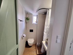 a small bathroom with a toilet and a window at The Handcrafted Haven 2 min to Central Square in Missolonghi