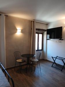 a room with a table and chairs and a television at La Casa nel Borgo in Muggia