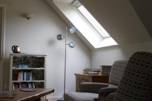 a room with two chairs and a book shelf at Au Jardin de Mireille in Leffrinkhoucke