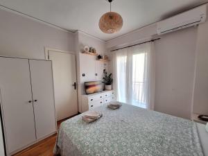 a white bedroom with a bed and a television at The Handcrafted Haven 2 min to Central Square in Missolonghi
