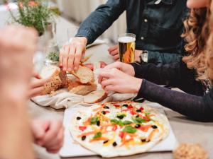 a group of people sitting around a table eating pizza at ibis Luebeck City in Lübeck