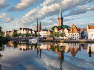 a city with a reflection in the water at ibis Luebeck City in Lübeck