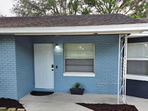 a blue brick house with a white door at White Door House! in Winter Haven