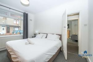 a bedroom with a large white bed and a window at Millfield House by Blue Skies Stays in Middlesbrough